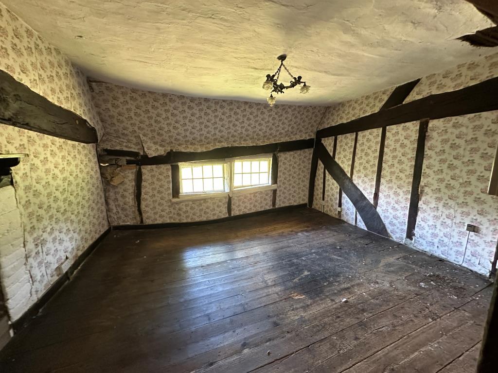 Lot: 115 - DETACHED THATCHED COTTAGE IN NEED OF REPAIR ON 1.36 ACRES OF LAND - Bedroom one with fireplace